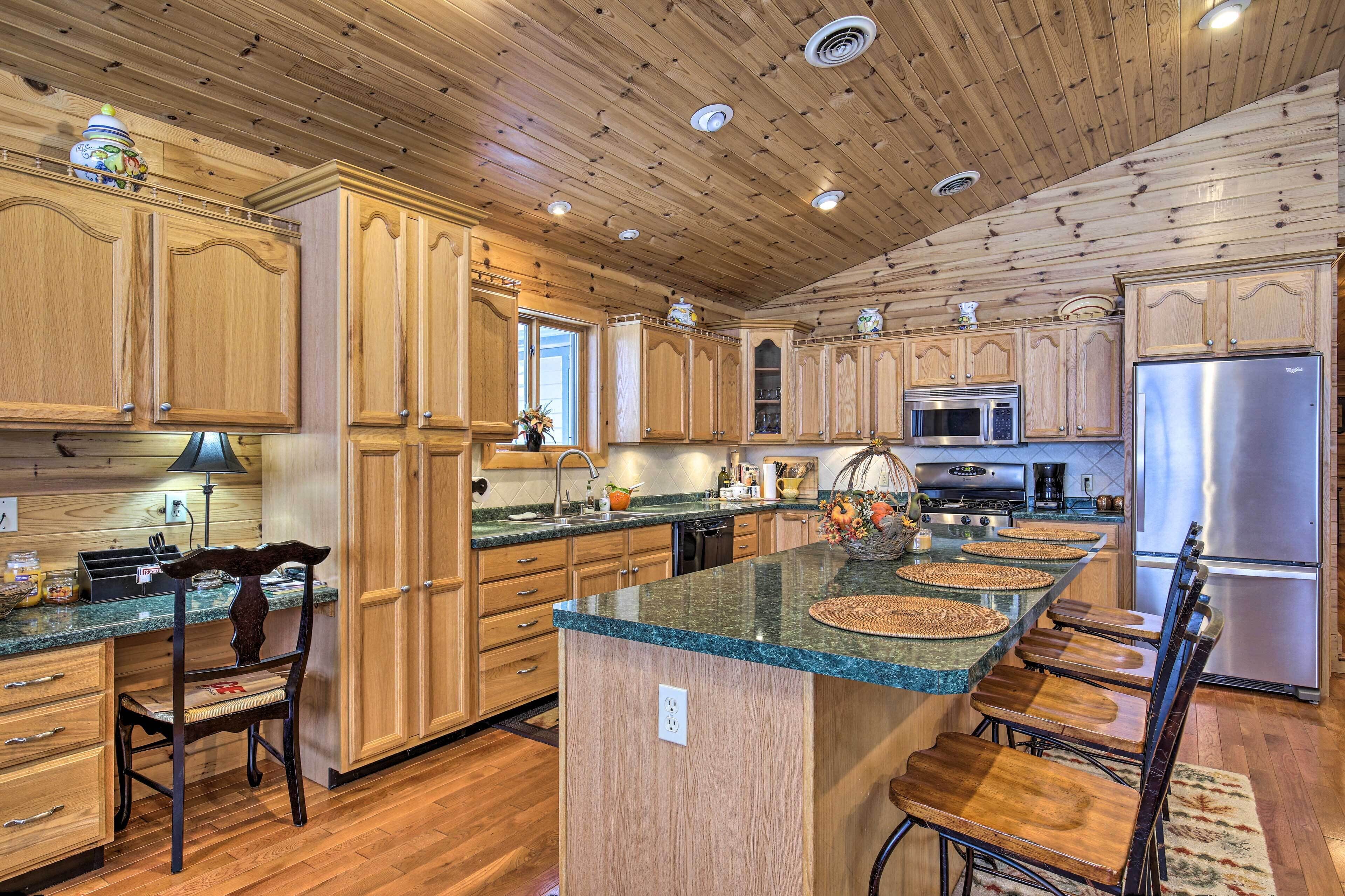 A spacious kitchen with wooden cabinets, granite countertops, and stainless steel appliances.