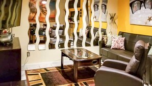A living room with a sofa, a coffee table, and a decorative wall panel. - 1 Block to Shore: Family Condo in Myrtle Beach! (Myrtle Beach)
