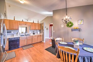 Enjoy meals in the kitchen and dining area with a wooden table and chairs.