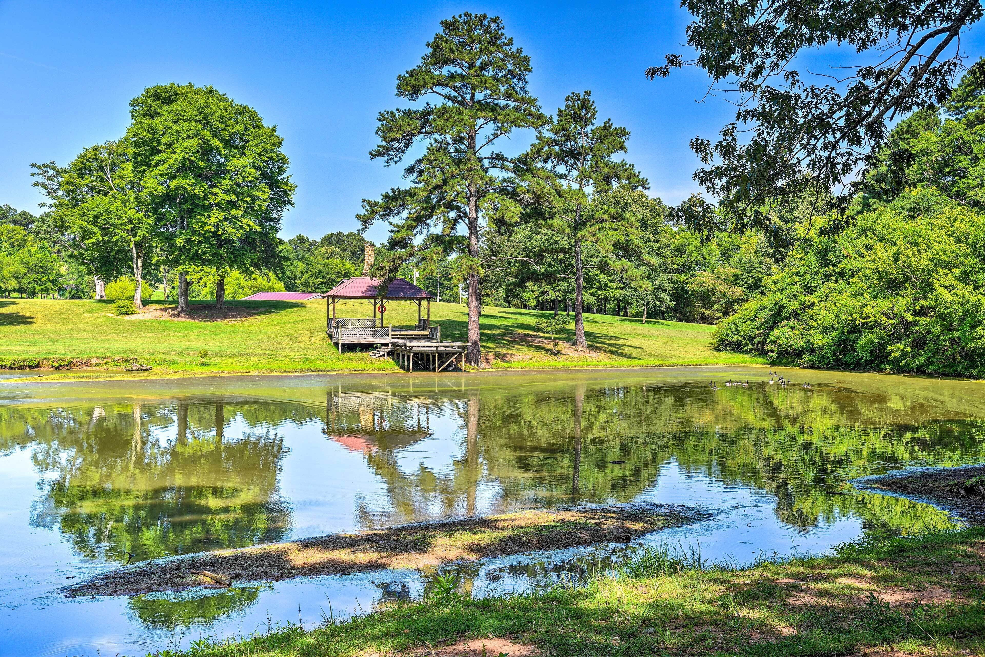 A serene park with a pond, trees, and a gazebo.