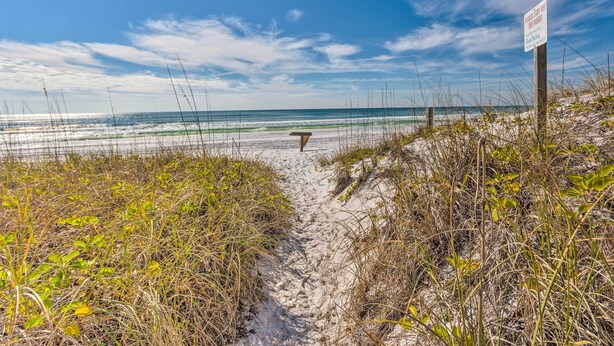 A sandy beach path leading to the ocean with a sign warning of tides. - Vibrant Family Condo: 100 Feet to Private Beach! (Miramar Beach)