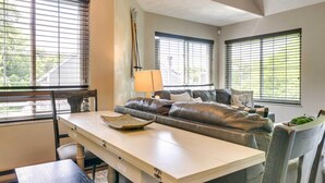 Een woonkamer met een bank, een tafel en een lamp.