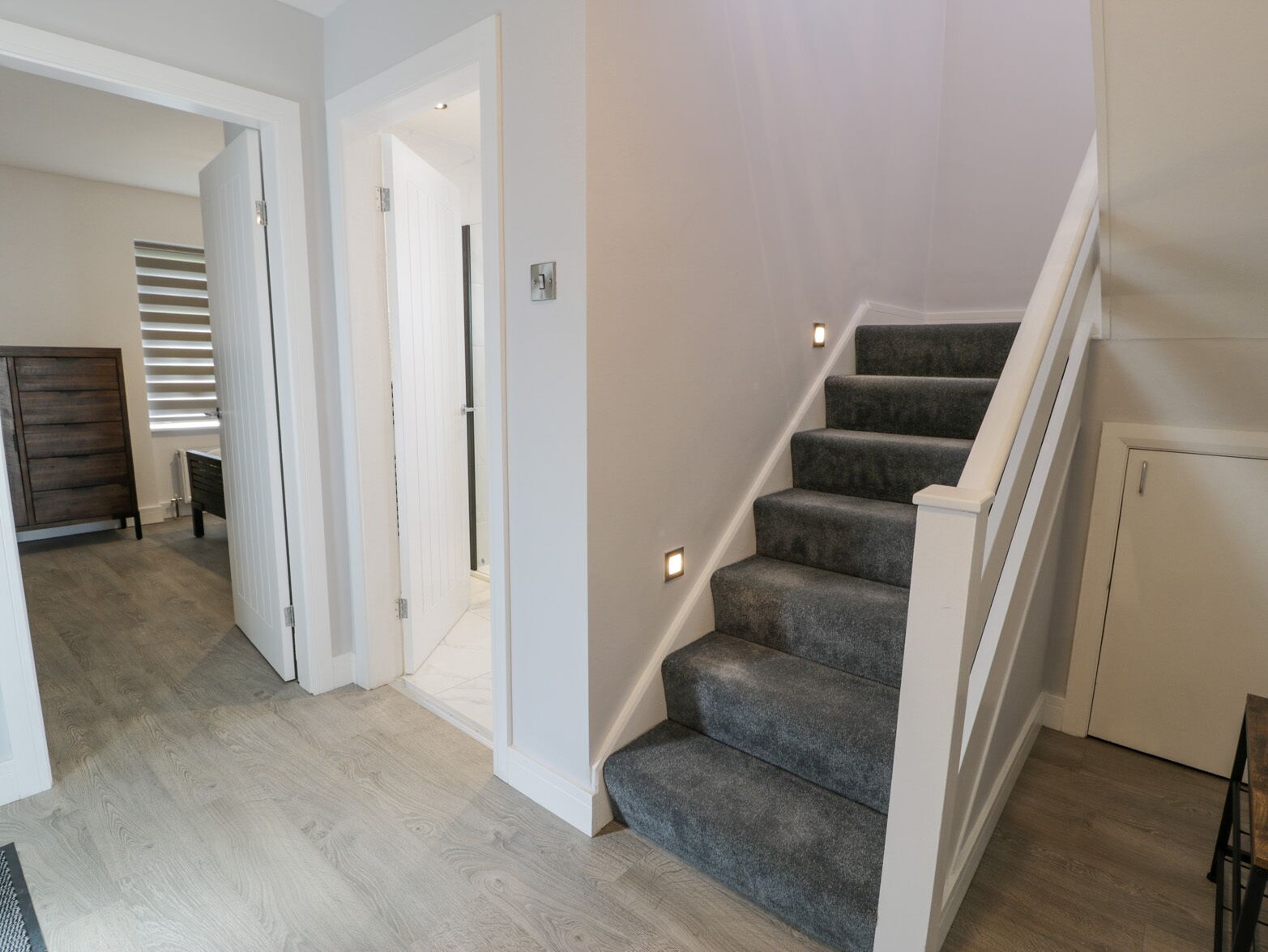 A staircase with carpeted steps leading to an upper floor.
