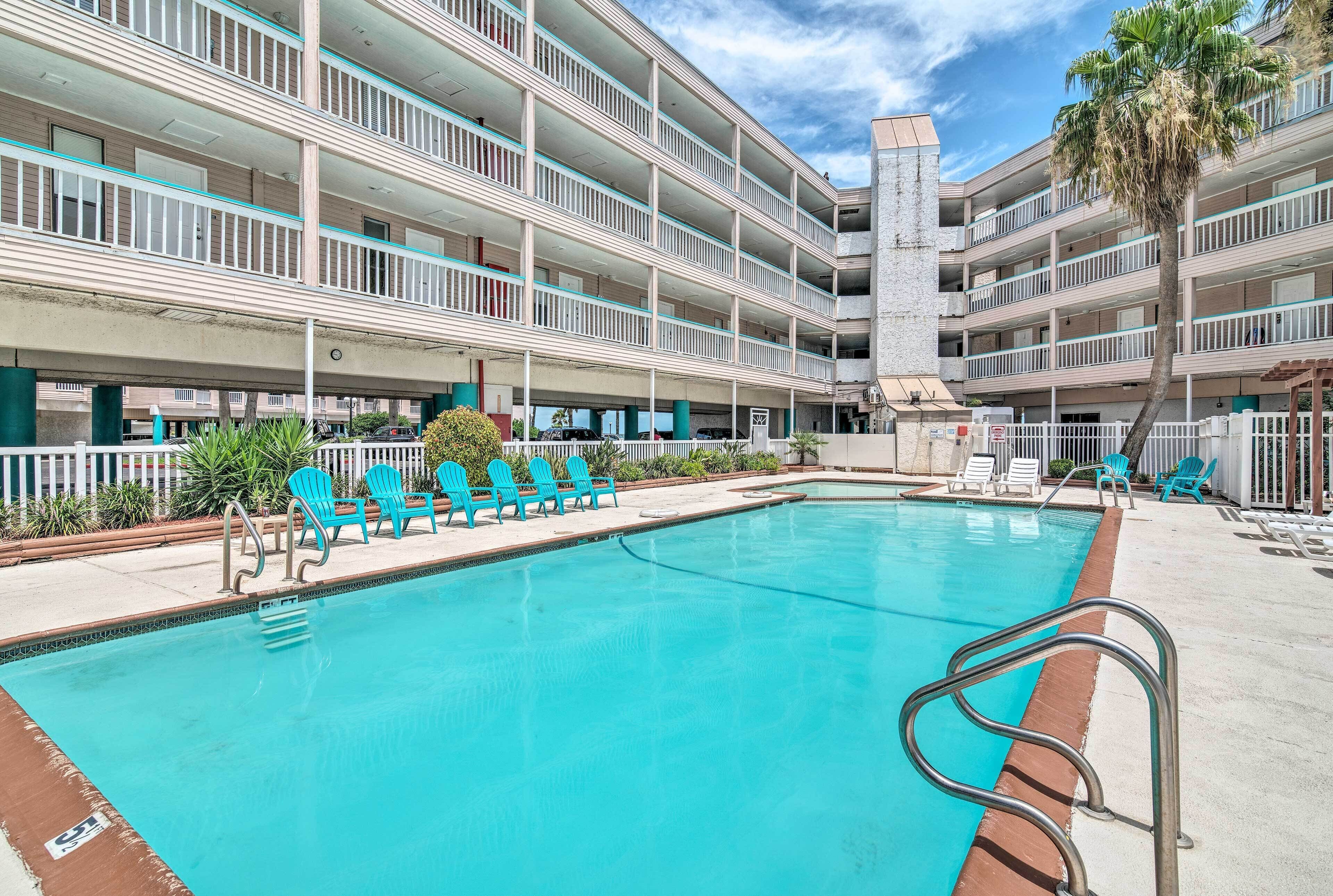 A multi-story hotel with a swimming pool, outdoor seating, and a palm tree.