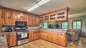 A kitchen with wooden cabinets, a stainless steel stove, and granite countertops. - Pet-friendly VA Home ~ 30 Mi to Shenandoah NP (Weyers Cave)