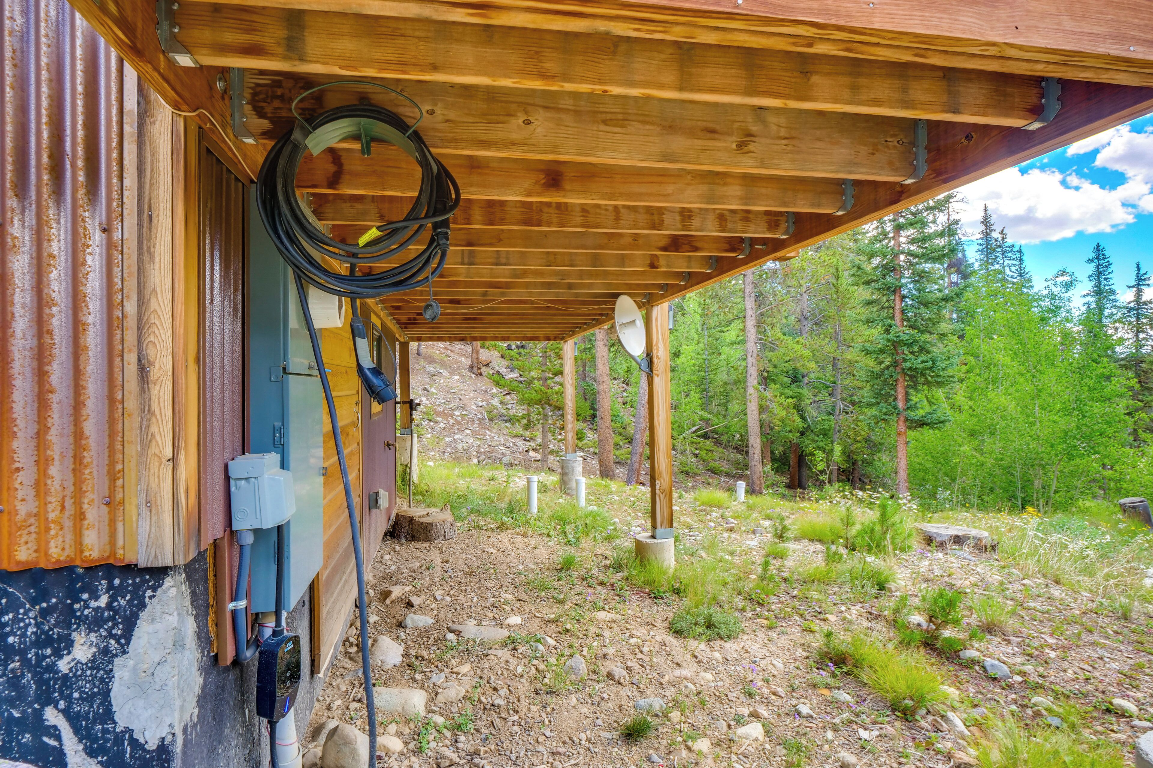Eine rustikale Holzhütte mit sichtbaren Holzbalken, einer Wellblechfassade und einer Holzdielenveranda.