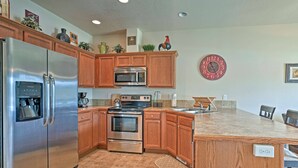 A modern kitchen with stainless steel appliances, wooden cabinets, and a central island. - Prime Snowy Retreat Mins to Tamarack & Mccall! (Donnelly)