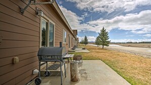 A house with a barbecue grill and outdoor seating. - Prime Snowy Retreat Mins to Tamarack & Mccall! (Donnelly)
