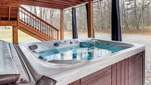 Un jacuzzi bajo una pérgola de madera con una escalera que lleva a él.