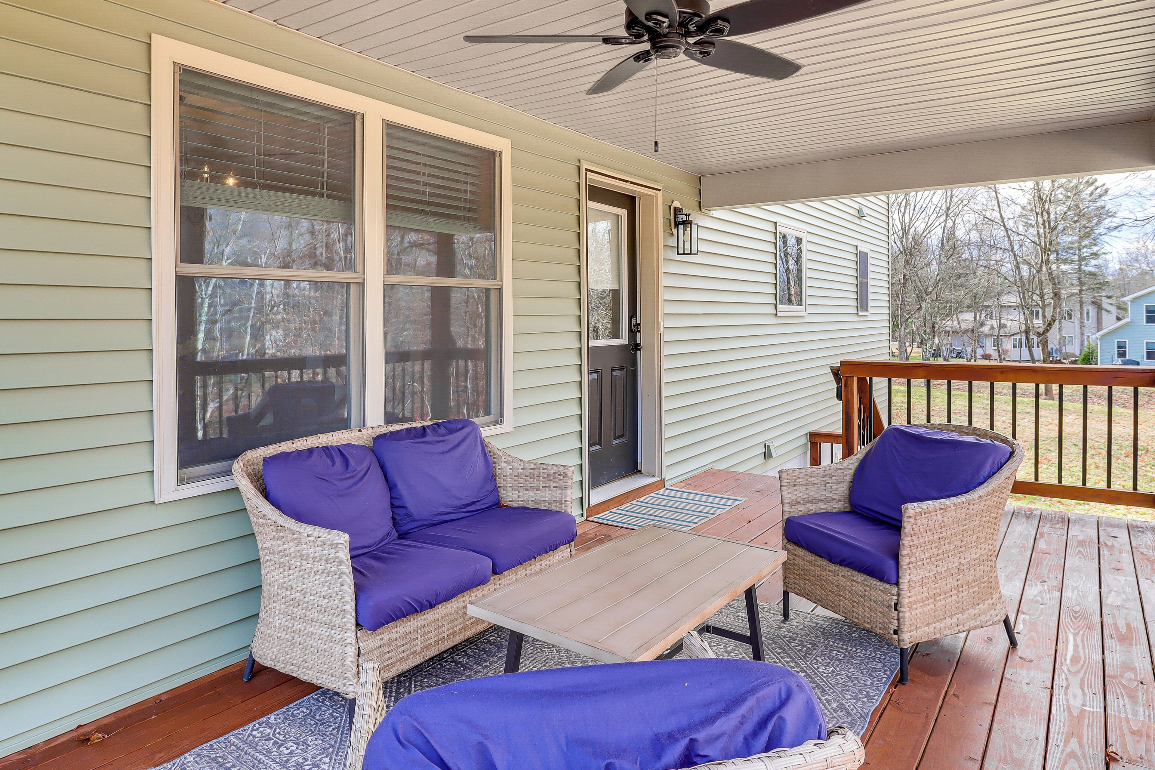 A covered porch with wicker furniture and a ceiling fan.