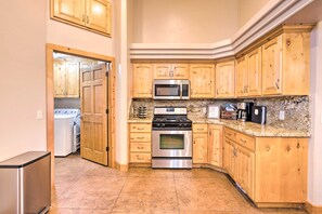 A kitchen with wooden cabinets, stainless steel appliances, and a granite countertop. - Hurricane Home w/ Pool & Spa ~ 25 Mi to Zion! (Hurricane)