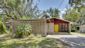 A small, single-story building with a brick exterior and a yellow door. - Charming Mid-century House - Just Steps to Lake! (Lakeland)