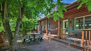 Eine Holzterrasse mit Picknicktischen und einer Hängematte.