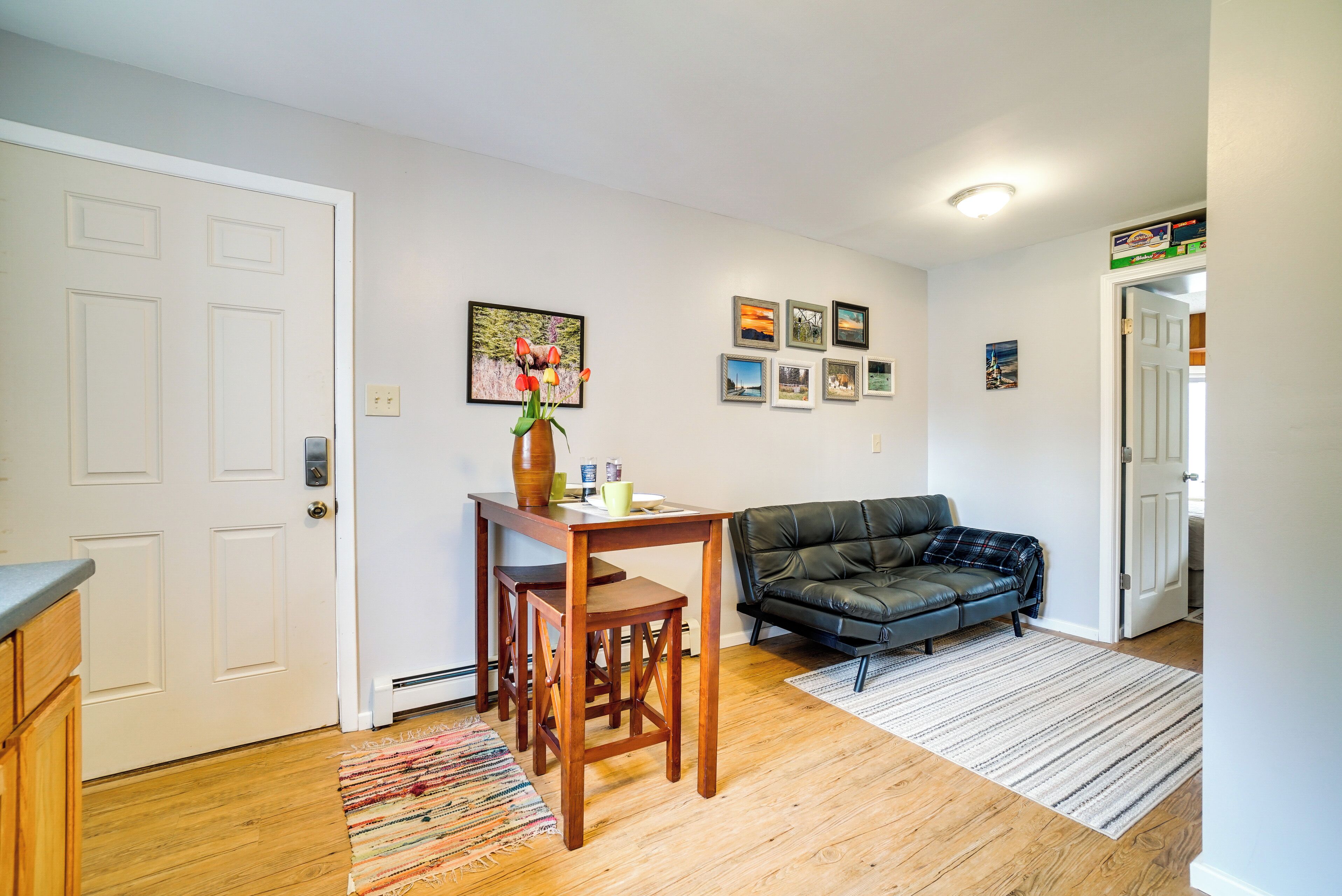 Een woonkamer met een bank, een eettafel met stoelen en een vloerkleed.