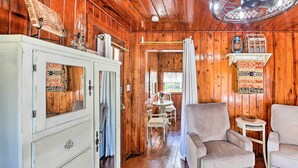 A wooden interior with a white cabinet, two armchairs, a small table, and a fan. - Hot Springs Studio ~ 3 Mi to National Park! (Hot Springs)