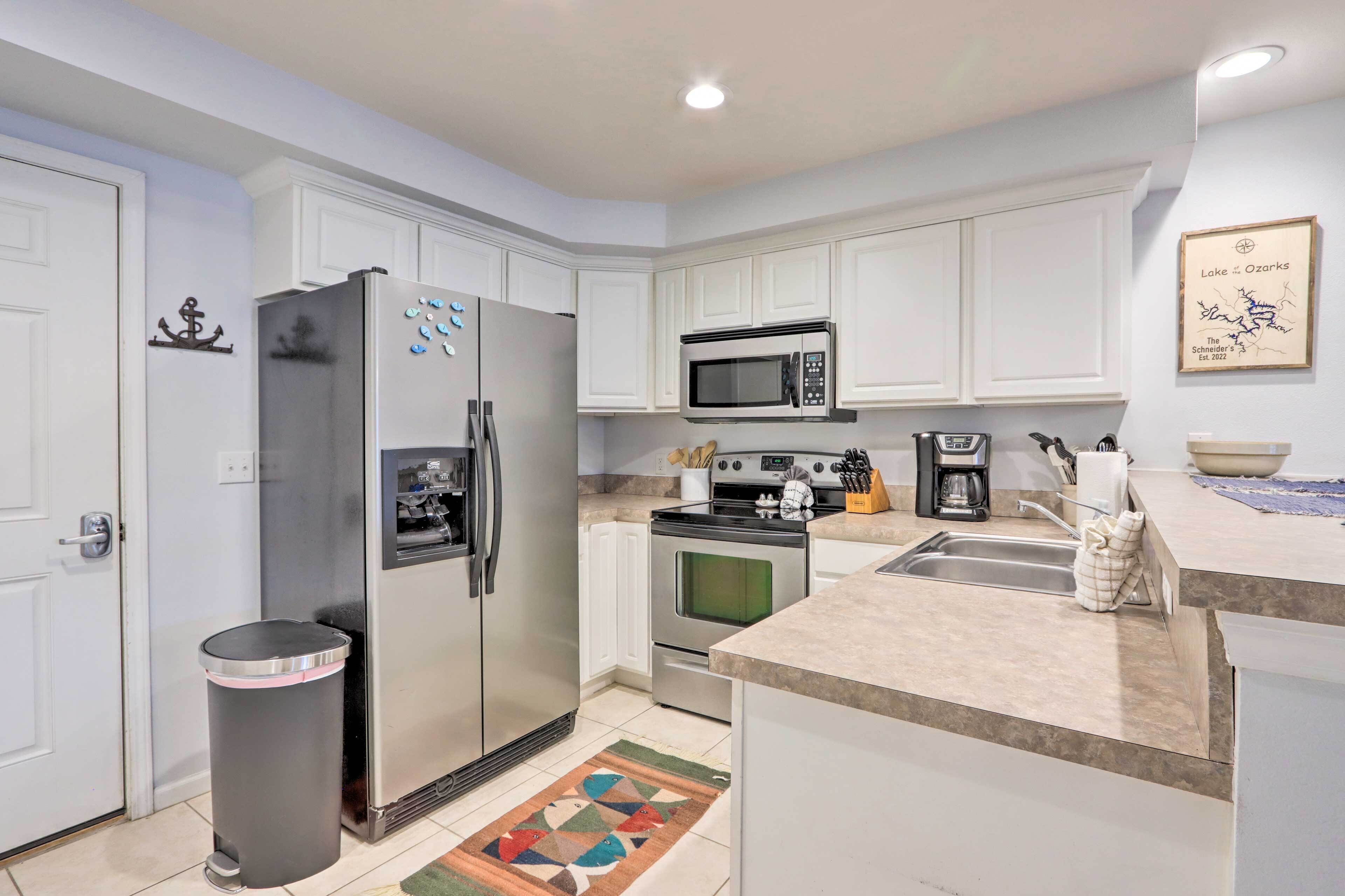 A modern kitchen with white cabinetry, stainless steel appliances, and a tiled backsplash.