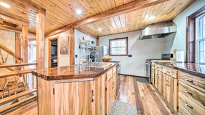 A spacious kitchen with wooden cabinets, a large island, and a view of the adjacent dining area.
