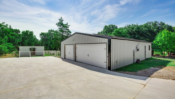 A single-story building with a garage door, a small attached structure, and a paved driveway. - Dog-friendly Home w/ Yard & Fire Pit in Midlothian (Midlothian)