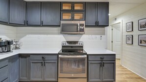 A kitchen with dark gray cabinets, a stainless steel oven, and a microwave. - Dog-friendly Home w/ Yard & Fire Pit in Midlothian (Midlothian)