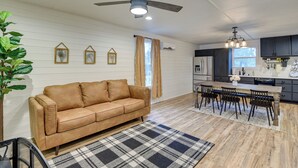 A modern kitchen with dark cabinets, a wooden dining table, and a ceiling fan. - Dog-friendly Home w/ Yard & Fire Pit in Midlothian (Midlothian)