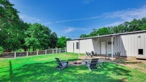 A fenced backyard with a covered patio area, outdoor seating, and a fire pit. - Dog-friendly Home w/ Yard & Fire Pit in Midlothian (Midlothian)
