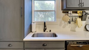 A kitchen with a double sink, a window, and a dish rack with utensils. - Dog-friendly Home w/ Yard & Fire Pit in Midlothian (Midlothian)