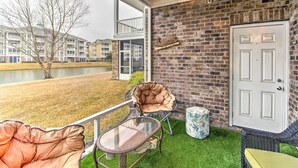 Ein Balkon mit Korbmöbeln, einer Tür und einer Ziegelwand.