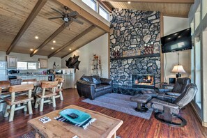 A spacious living area with a stone fireplace, leather seating, and a wooden ceiling. - Lavish Ruidoso Condo w/ 2 Private Decks & Hot Tub! (Ruidoso)