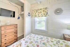 Une chambre à coucher comprenant un lit, une commode, une fenêtre et des éléments décoratifs sur les murs.