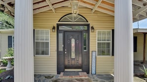 A house with a dark front door, a welcome sign, and a stone-paved entrance. - Game Room & Views: Lakefront Shelby Home! (Shelby)