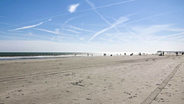 A wide sandy beach with footprints and a pier in the distance. - Ground Floor Unit: 10 Miles to Myrtle Beach (Murrells Inlet)