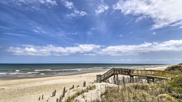 A beach with a wooden boardwalk leading to the shore. - Home w/ Deck in Corolla Light: Walk to Beach! (Corolla)