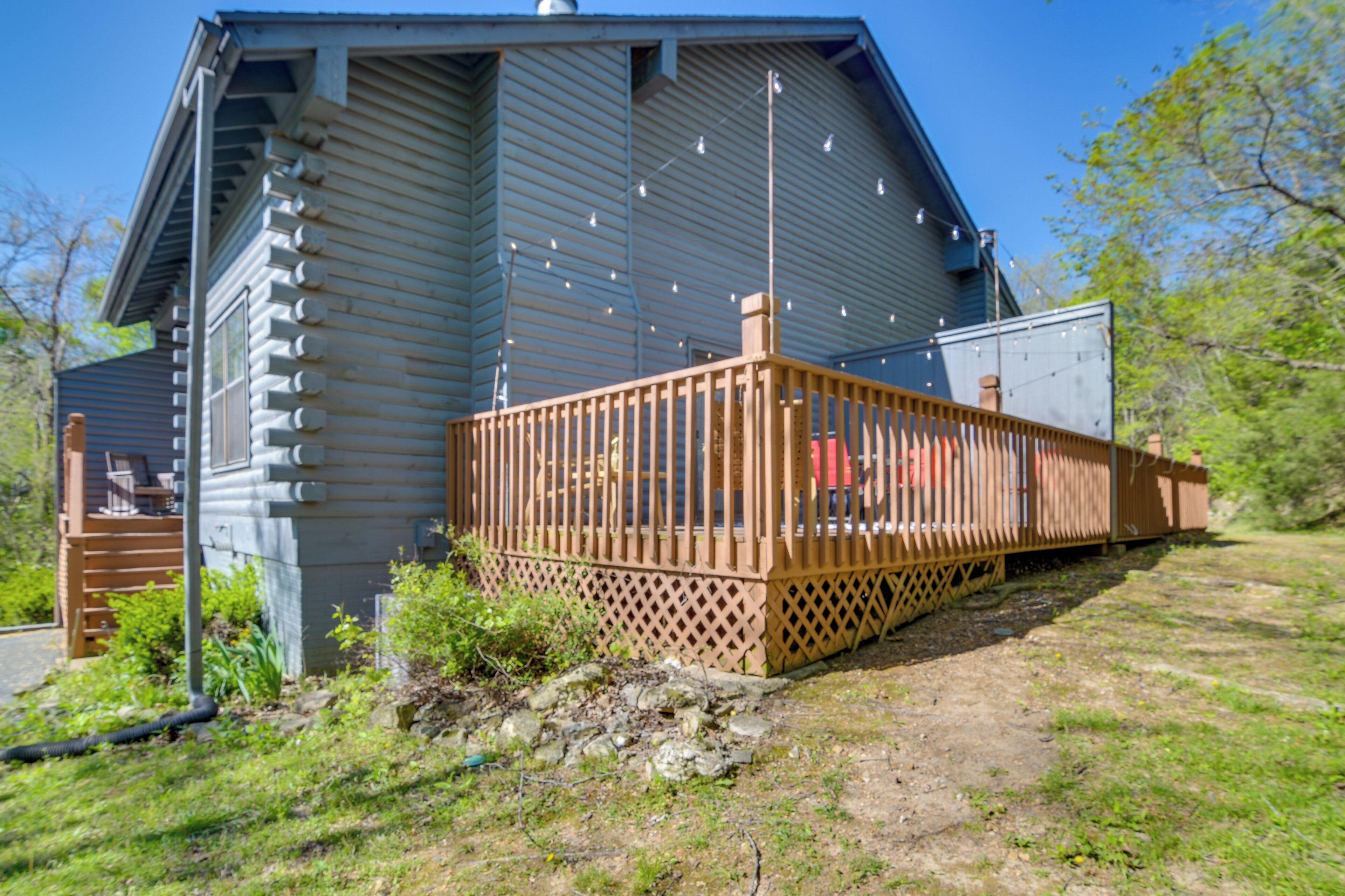 A two-story house with a wooden deck and a chimney.