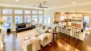 A spacious living room with a sofa, coffee table, and a kitchen area with a bar and stools. - 10 Mi to New Braunfels: Waterfront Seguin Gem (Seguin)
