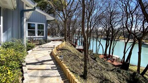 A stone pathway leading to a lakeside deck with a view of the lake and trees. - 10 Mi to New Braunfels: Waterfront Seguin Gem (Seguin)