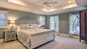 A bedroom with a bed, nightstand, lamp, decorative wall piece, and a view of the outdoors through a window. - 10 Mi to New Braunfels: Waterfront Seguin Gem (Seguin)