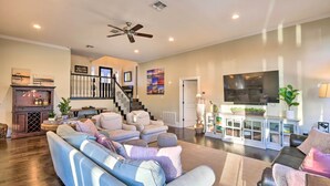 A spacious living room with a large sectional sofa, a fireplace, a television, and a staircase leading to another level. - 10 Mi to New Braunfels: Waterfront Seguin Gem (Seguin)