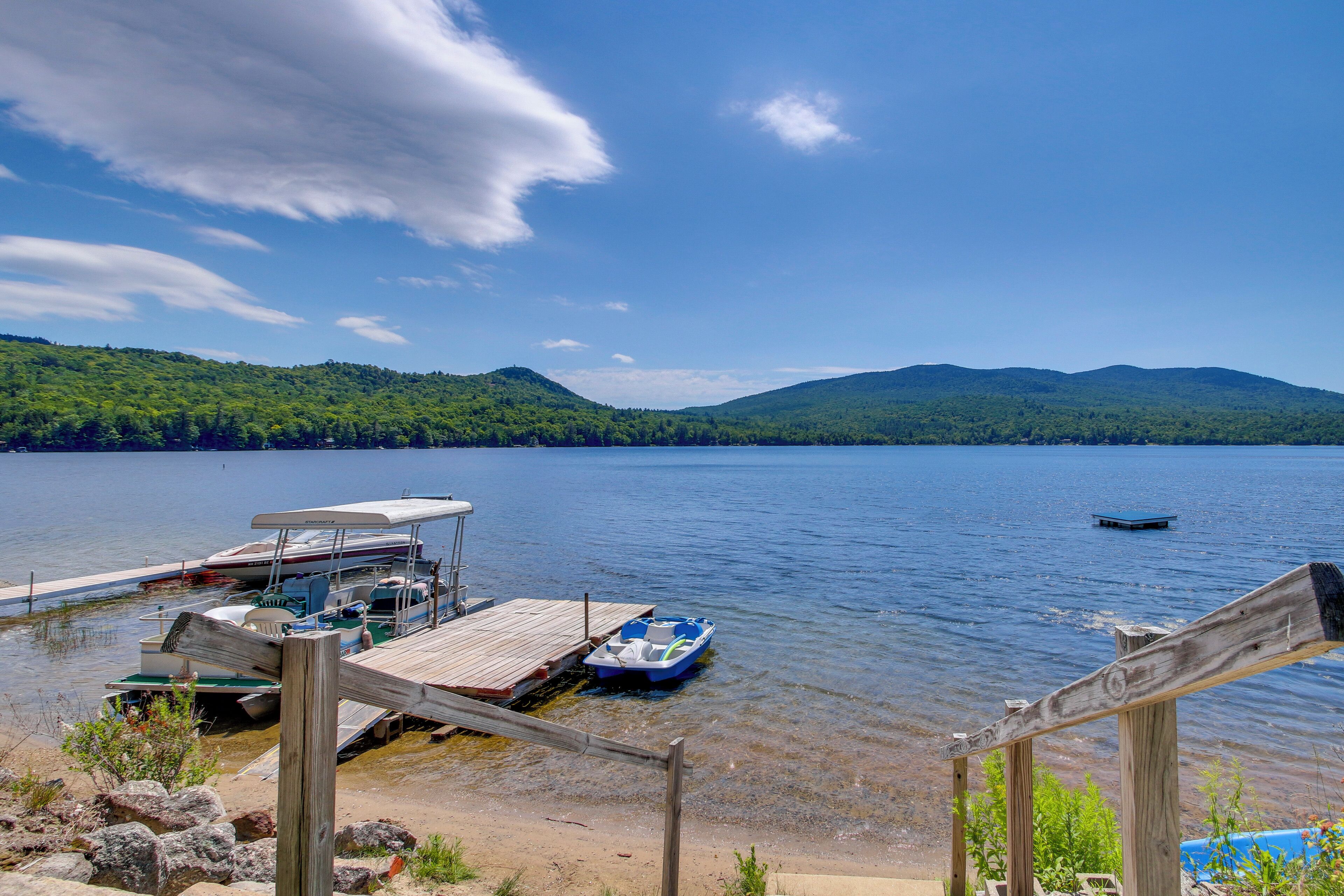 A lakeside dock with boats and a wooden pier.