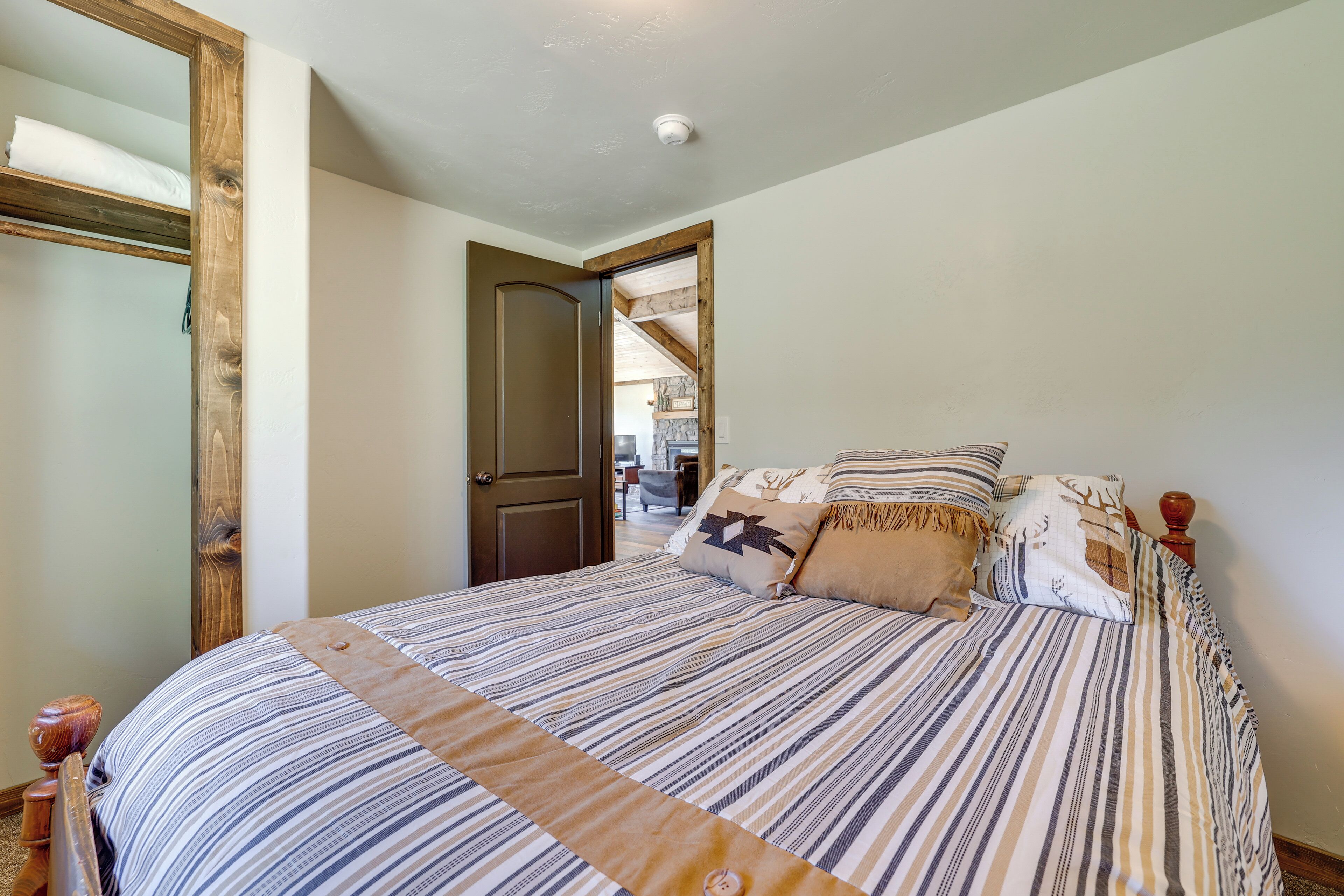 A bedroom with a large bed, wooden headboard, and a door leading to another room.