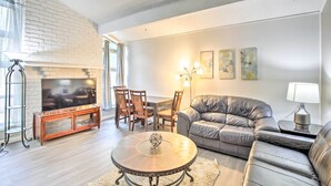 A living room with a fireplace, a TV, a sofa, and a dining table with chairs.