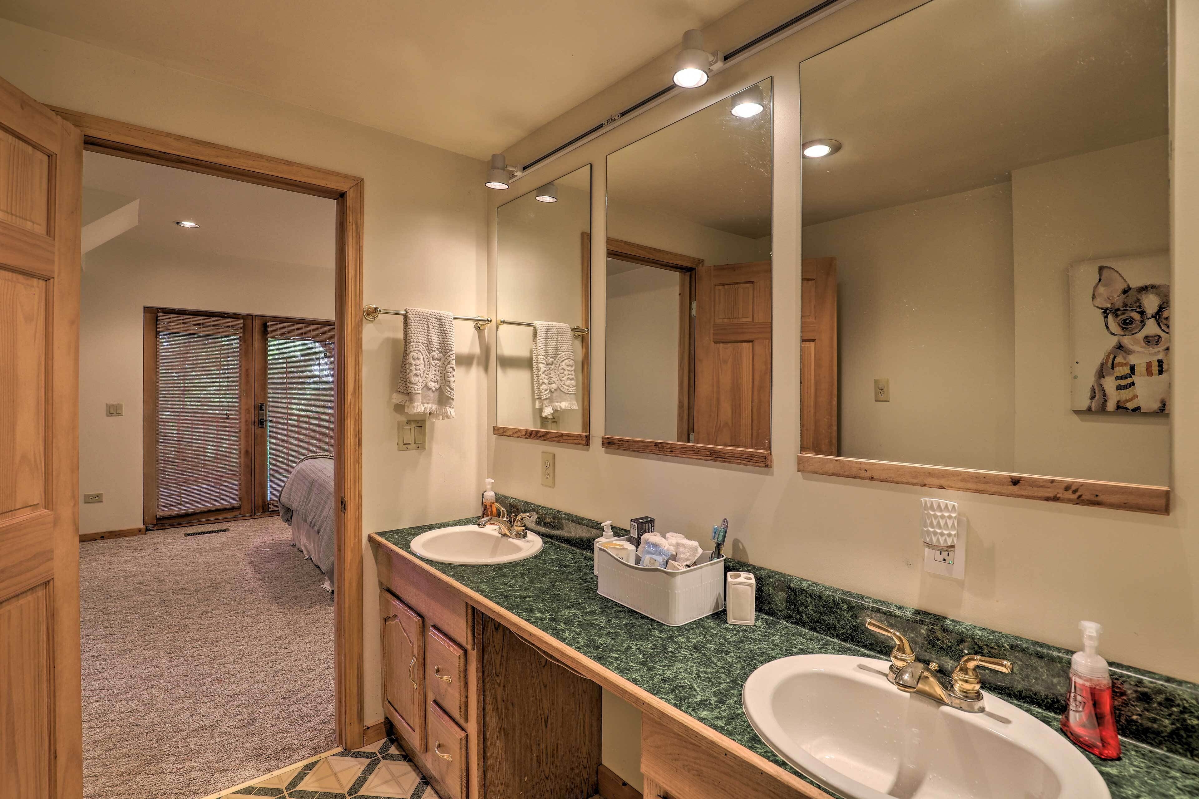 A bathroom with two sinks, a large mirror, and a wooden vanity.