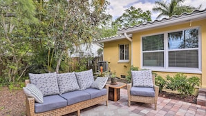 A patio area with a wicker sofa and two chairs, a small table, and a potted plant. - Florida Home ~ 10 Mi to St Pete Beach! (St. Petersburg)