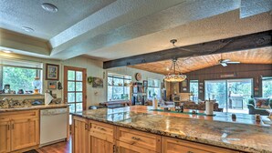 A spacious kitchen with wooden cabinets, granite countertops, and a large island. - Gorgeous Oakhurst Retreat w/ Swimming Hole! (Oakhurst)