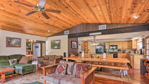 A spacious living room with a wooden ceiling, a dining area, and a kitchen. - Gorgeous Oakhurst Retreat w/ Swimming Hole! (Oakhurst)