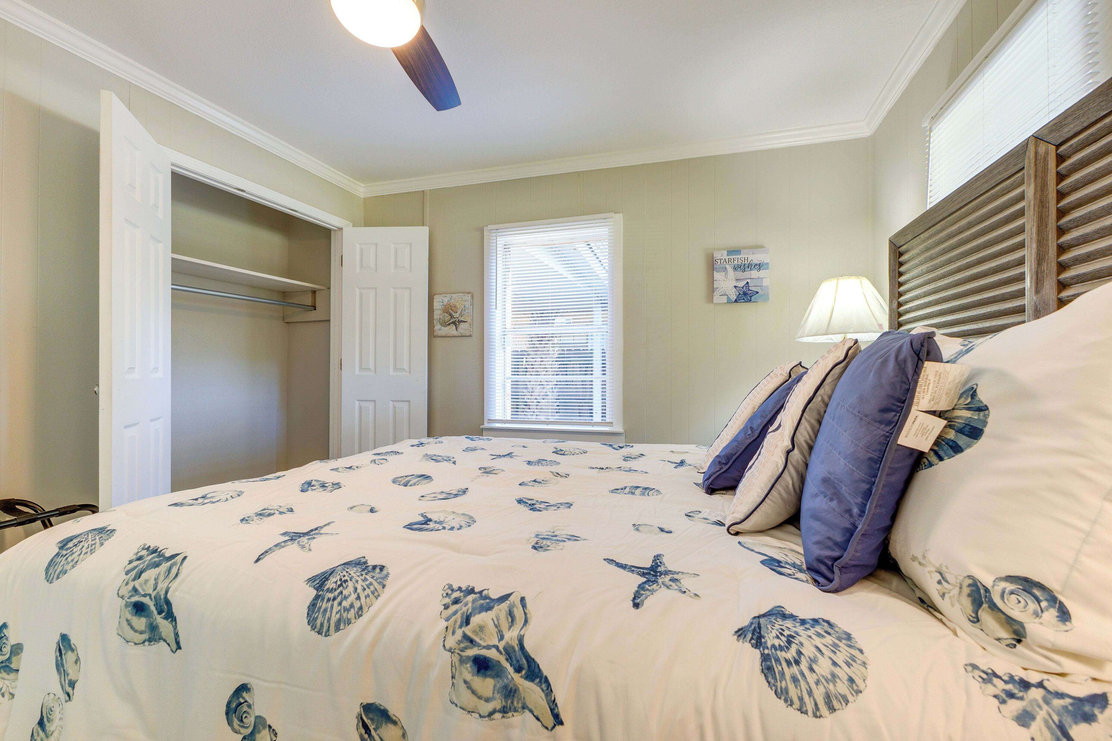 A bedroom with a bed, a closet, a window with blinds, and a ceiling fan.