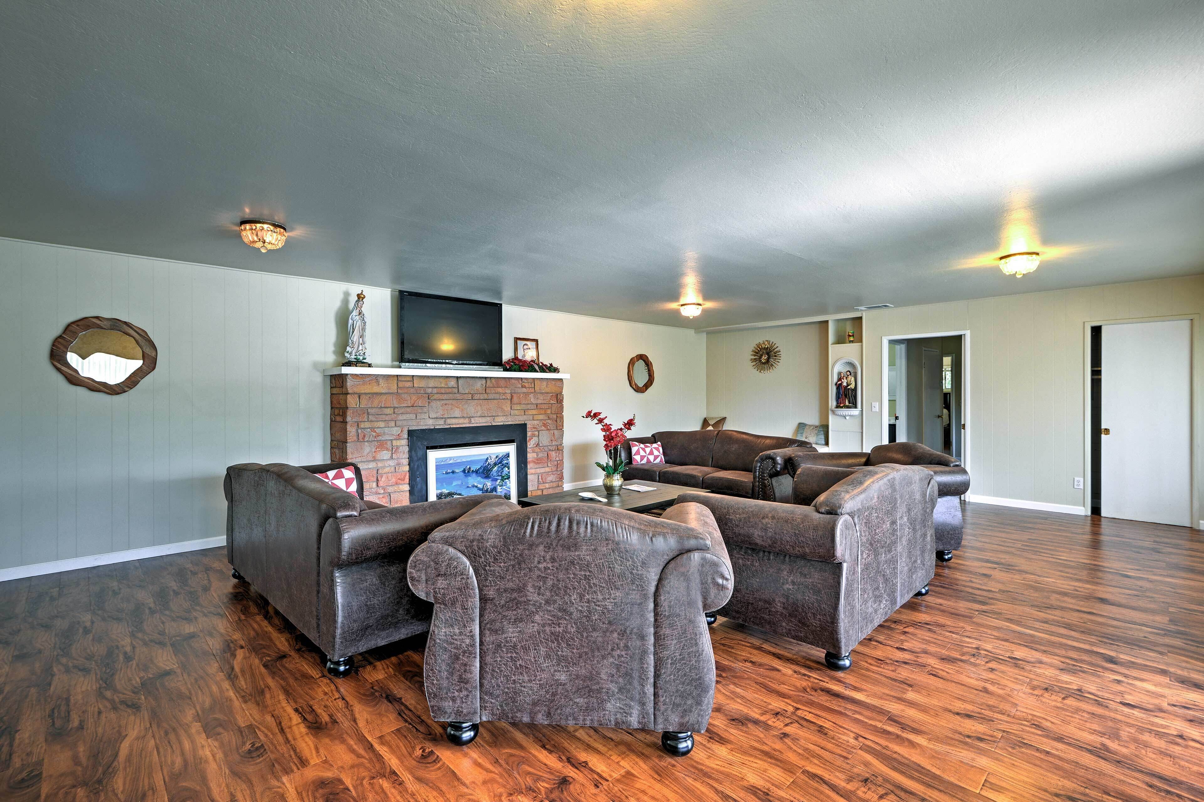 Ein geräumiges Wohnzimmer mit Kamin, Ledersofas und Holzböden.