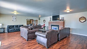 Ein Wohnzimmer mit Kamin, Ledersofas und Holzboden.