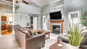 A living room with a leather sofa, a coffee table, a fireplace, and a television. - Indian Lake Escape for Fall Fishing & Biking (Huntsville)