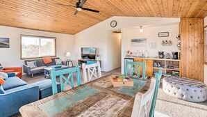 Un salon chaleureux avec un plafond en bois, un canapé, une table basse et un téléviseur.