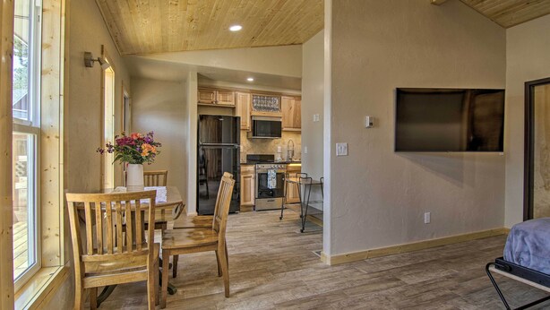 A spacious kitchen with wooden cabinets, a stainless steel refrigerator, and a microwave. - Mountain Cabin, Walk to Dining/memorial Park! (Woodland Park)